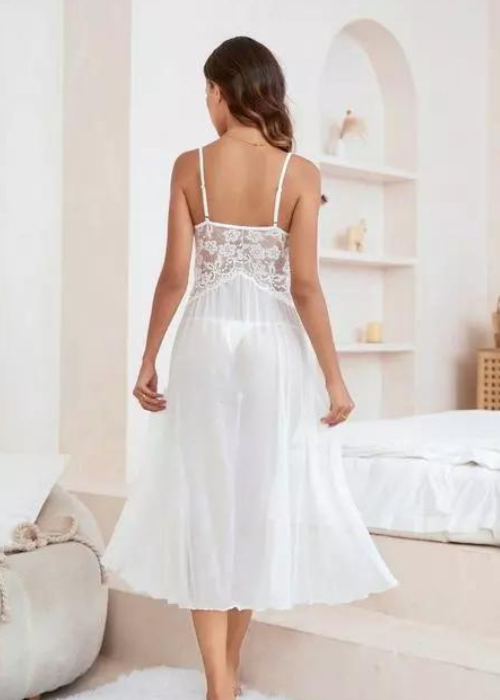 Woman wearing a white lace nightgown in a bedroom setting